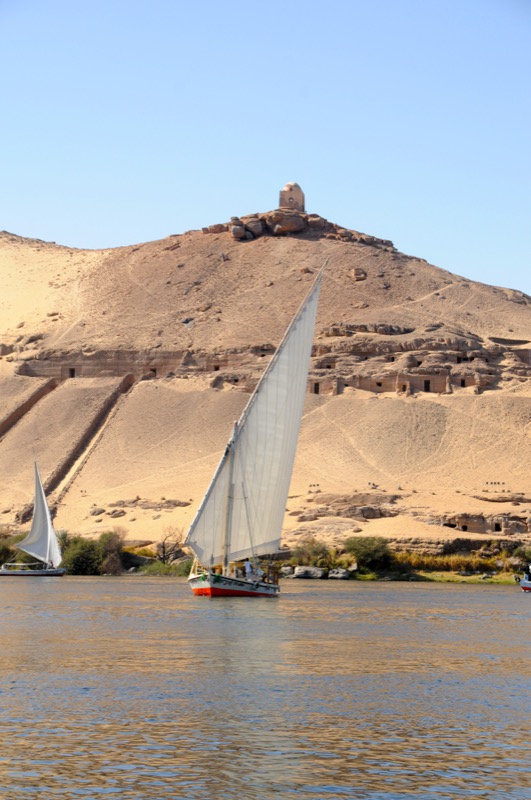 Traditional felucca sailing boat crossing the Nile near Aswan in the late afternoon